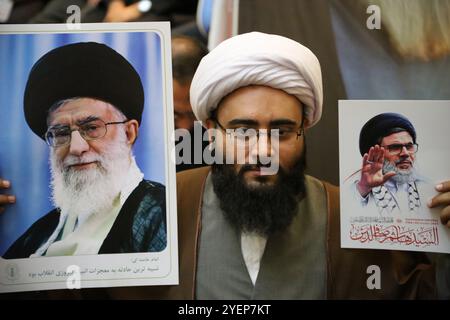 Téhéran, Iran. 31 octobre 2024. Un ecclésiastique iranien brandit une affiche du Guide suprême iranien, l'ayatollah Ali Khamenei (à gauche) et tua le religieux libanais Hashem Safieddine (à droite) lors d'une cérémonie sur la place Palestine à Téhéran, commémorant feu Hashem Safieddine, un religieux éminent qui devait succéder au dirigeant du Hezbollah assassiné Hassan Nasrallah, tué par une frappe aérienne israélienne à Beyrouth. (Crédit image : © Rouzbeh Fouladi/ZUMA Press Wire) USAGE ÉDITORIAL SEULEMENT! Non destiné à UN USAGE commercial ! Banque D'Images