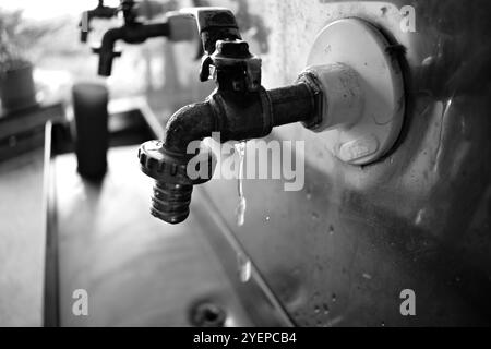 Une fontaine d'eau potable en acier inoxydable avec des robinets métalliques dans une rangée, le premier qui libère l'eau est fermé et les autres robinets en arrière-plan ne sont pas non plus Banque D'Images