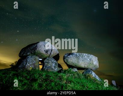 Borre, Danemark. 30 octobre 2024. Ciel étoilé la nuit au-dessus de Sömarkedyssen, également connu sous le nom de dolmen de Sömarke, est un site mégalithique datant de l'âge de pierre vers 3 400 av. J.-C. sur l'île de Mön sur la mer Baltique. Sous la grande pierre angulaire du dolmen le plus connu de Mön se trouve une chambre octogonale avec un court passage. La pierre angulaire du passage est célèbre pour ses 445 petits bols, qui remontent probablement à l'âge du bronze. Crédit : Patrick Pleul/dpa/Alamy Live News Banque D'Images