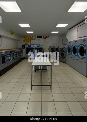 Nettoyer l'intérieur de la laverie automatique avec lave-linge et sèche-linge alignés. Photo de haute qualité Banque D'Images