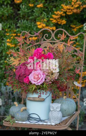 arrangement d'automne avec un bouquet de roses roses roses, fleurs d'hortensia, hanches de roses et branches d'érable dans un pot à lait vintage et des citrouilles Banque D'Images