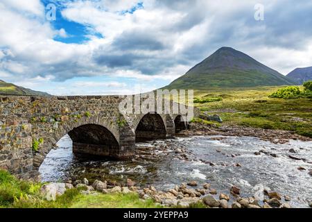 L'ancien pont de pierre de Sligachen traverse la rivière dans l'île de Skye, dans les Hébrides intérieures, en Écosse. Les montagnes Cuillin peuvent être vues en arrière-plan. Banque D'Images