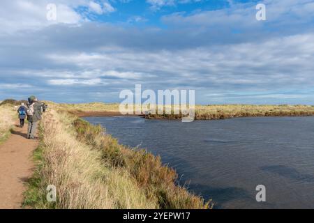 Vue de la réserve naturelle RSPB Titchwell Marsh dans le nord du Norfolk, Angleterre, Royaume-Uni, avec un groupe d'ornithologues pendant l'automne Banque D'Images