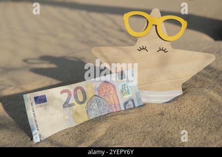 Argent 20 euros billets dans la plage de sable avec étoiles de mer. Concept finance économiser de l'argent pour les vacances. Coûts en vacances de voyage. Ombres Banque D'Images