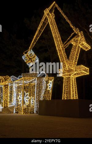 Grue de construction symbole de Shipyard Holiday décorations illuminées à Gdansk Pologne. Belle foire de Noël la nuit. Heure d'hiver de l'Avent à Europ Banque D'Images