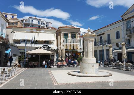 Place animée avec une fontaine centrale, entourée de cafés et de bâtiments historiques, vieille fontaine, place Karamanou, Poros, île de Poros, Saronic Islan Banque D'Images