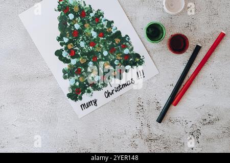 Bricolage faire une carte de voeux artisanat fait main pendant les vacances pour les enfants.Étape par étape.Faites-le vous-même.Bonne année Noël décoration d'arbre peinture avec les doigts Banque D'Images