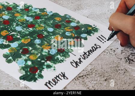 Bricolage faire une carte de voeux artisanat fait main pendant les vacances pour les enfants.Peindre avec les doigts arbre de Noël joyeux.Étape par étape.Faites-le vous-même.Bonne nouvelle Yea Banque D'Images