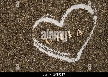 Coeur fait de graines de chia avec le mot CHIA à l'intérieur de l'arrière-plan. Un super-aliment sain riche en acides gras oméga-3. Ingrédient naturel sain et sec. Végétarien f Banque D'Images