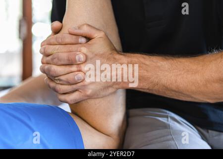 Vue rapprochée des mains masseuses massant les jambes du sportif masculin. Massothérapeute travaillant avec la pression sur les jambes. Massage thérapeutique du corps Banque D'Images