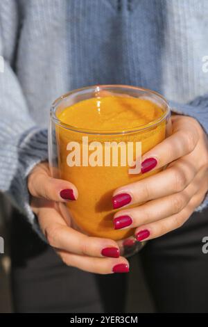 Femme méconnaissable portant un smoothie pimpkin épicé latte. Café d'automne avec boisson chaude de saison au goût de citrouille épicée. Boissons d'automne pour Halloween et Banque D'Images