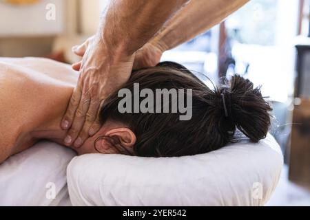 Thérapeute professionnel offrant un massage doux du cou à la femme. Vue rapprochée du massage des soins du corps en cours. Femme recevant un massage du cou dans le centre thermal Banque D'Images