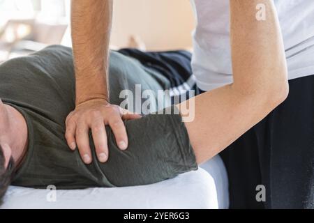 Un homme qui reçoit un massage. Image recadrée d'un massothérapeute professionnel travaillant sur une main de sportif. Un homme recevant un massage des mains Banque D'Images