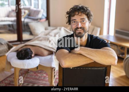 Joyeux portrait de masseuse et une jeune femme se reposant après un massage naturel relaxant sur le fond. Massothérapeute gai Banque D'Images
