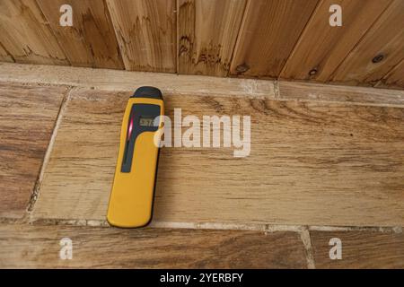 Un détecteur d'humidité du bois est considérée close up avec copie-espace, au cours d'une inspection de la qualité de l'environnement intérieur, indiquant un haut niveau d'humidité avec r Banque D'Images