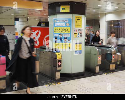 TOKYO, JAPON - 30 octobre 2024 : passagers passant par les portes d'entrée de la station Omotesando du métro de Tokyo. Banque D'Images