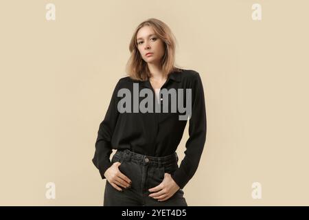 Série de photos de studio de femme dans une tenue décontractée élégante classique - pantalon en denim noir, chemise boutonnée noire et talons hauts. Banque D'Images