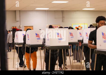 Baltimore, États-Unis. 31 octobre 2024. 31 octobre 2024, Baltimore City, Maryland, États-Unis. De très longues files de personnes attendant de voter la dernière nuit du vote anticipé à l'élection présidentielle de 2024. Tous les électeurs en ligne à 20 heures HNE allaient voter. Certaines personnes portaient des costumes d'Halloween. Beaucoup de gens ont amené leurs enfants à témoigner de cette élection historique où les sondages sont très proches. (Photo de Robyn Stevens Brody/Sipa USA) crédit : Sipa USA/Alamy Live News Banque D'Images