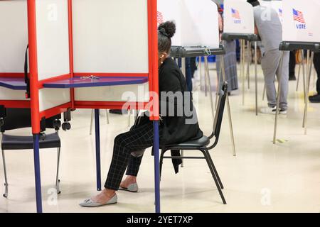 Baltimore, États-Unis. 31 octobre 2024. 31 octobre 2024, Baltimore City, Maryland, États-Unis. De très longues files de personnes attendant de voter la dernière nuit du vote anticipé à l'élection présidentielle de 2024. Tous les électeurs en ligne à 20 heures HNE allaient voter. Certaines personnes portaient des costumes d'Halloween. Beaucoup de gens ont amené leurs enfants à témoigner de cette élection historique où les sondages sont très proches. (Photo de Robyn Stevens Brody/Sipa USA) crédit : Sipa USA/Alamy Live News Banque D'Images