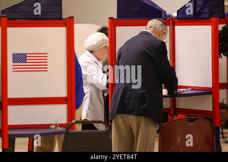 Baltimore, États-Unis. 31 octobre 2024. 31 octobre 2024, Baltimore City, Maryland, États-Unis. De très longues files de personnes attendant de voter la dernière nuit du vote anticipé à l'élection présidentielle de 2024. Tous les électeurs en ligne à 20 heures HNE allaient voter. Certaines personnes portaient des costumes d'Halloween. Beaucoup de gens ont amené leurs enfants à témoigner de cette élection historique où les sondages sont très proches. (Photo de Robyn Stevens Brody/Sipa USA) crédit : Sipa USA/Alamy Live News Banque D'Images