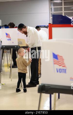 Baltimore, États-Unis. 31 octobre 2024. 31 octobre 2024, Baltimore City, Maryland, États-Unis. De très longues files de personnes attendant de voter la dernière nuit du vote anticipé à l'élection présidentielle de 2024. Tous les électeurs en ligne à 20 heures HNE allaient voter. Certaines personnes portaient des costumes d'Halloween. Beaucoup de gens ont amené leurs enfants à témoigner de cette élection historique où les sondages sont très proches. (Photo de Robyn Stevens Brody/Sipa USA) crédit : Sipa USA/Alamy Live News Banque D'Images