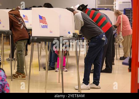 Baltimore, États-Unis. 31 octobre 2024. 31 octobre 2024, Baltimore City, Maryland, États-Unis. De très longues files de personnes attendant de voter la dernière nuit du vote anticipé à l'élection présidentielle de 2024. Tous les électeurs en ligne à 20 heures HNE allaient voter. Certaines personnes portaient des costumes d'Halloween. Beaucoup de gens ont amené leurs enfants à témoigner de cette élection historique où les sondages sont très proches. (Photo de Robyn Stevens Brody/Sipa USA) crédit : Sipa USA/Alamy Live News Banque D'Images