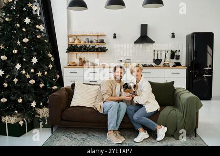 Un couple profite d'un moment chaleureux à la maison avec son chien, entouré de décorations de vacances. Banque D'Images