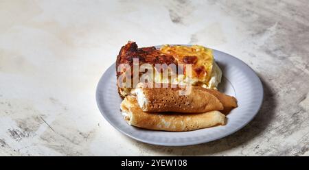 Galets de crêpes avec fromage cottage et raisins secs et portion de cocottage en cocottage dans l'assiette. Un délicieux dessert sucré Banque D'Images