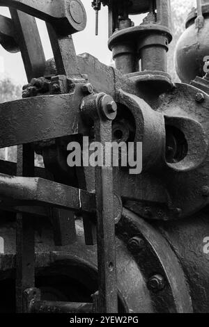 Pièces massives de machine industrielle noire vintage, gros plan photo noir et blanc avec mise au point sélective, fond abstrait de l'industrie lourde Banque D'Images