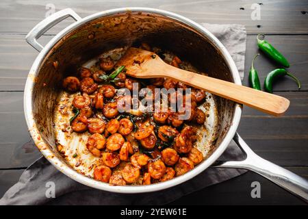 Saute de Tom Rim (crevettes caramélisées vietnamiennes) : fruits de mer d'Asie du Sud-est avec sauce épaisse, oignons verts, piments et une spatule en bambou Banque D'Images