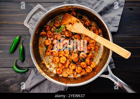 Saute de Tom Rim (crevettes caramélisées vietnamiennes) : fruits de mer d'Asie du Sud-est avec sauce épaisse, oignons verts, piments et une spatule en bambou Banque D'Images