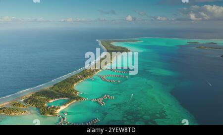 Vue aérienne des îles Maldives, de nombreux bungalows sur l'eau et des stations balnéaires dans l'eau turquoise du lagon. Luxe voyage vacances hôtel huttes dans la baie de l'océan récif de corail. Vol par drone au-dessus d'un paradis tropical exotique Banque D'Images