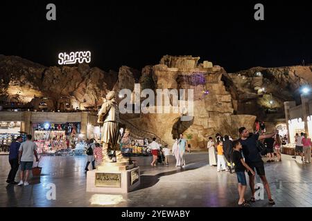 Sharm El Sheikh, Egypte - 28 avril 2024 : père et fils prenant des selfies sur téléphone portable à l'ancienne place du marché près de la cascade artificielle et monument Banque D'Images