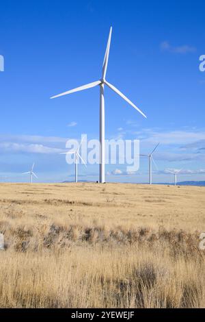 Éolienne debout haut au-dessus du paysage aride sec contre le ciel bleu Banque D'Images