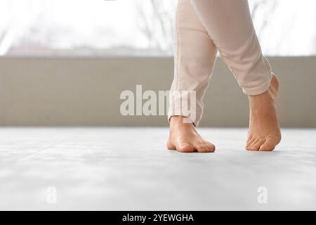 Jeune femme marchant sur un nouveau plancher stratifié à la maison Banque D'Images