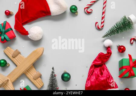 Cadre fait de jouets, avion en bois et chapeau de Père Noël sur fond blanc. Concept de vacances de Noël Banque D'Images