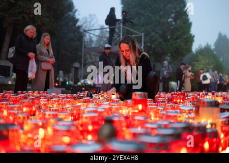 Zagreb, Croatie. 01 novembre 2024. Une femme allume une bougie pendant la soirée au cimetière de Mirogoj à l'occasion de la Toussaint, à Zagreb, Croatie, le 1er novembre 2024. Photo : Neva Zganec/PIXSELL crédit : Pixsell/Alamy Live News Banque D'Images