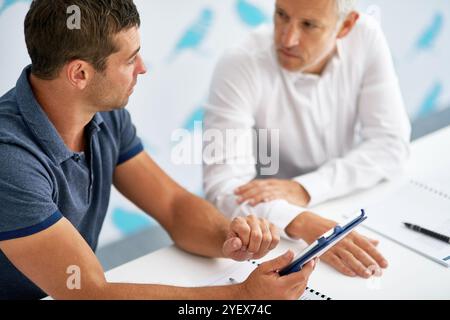 Documents, tablette et hommes d'affaires en bureau pour réunion pour révision, recherche et projet en ligne. Entreprise, professionnel et patron avec travailleur sur Banque D'Images