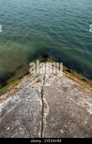 vol de marches de pierre menant à la mer pour accéder à l'eau à marée basse. Banque D'Images