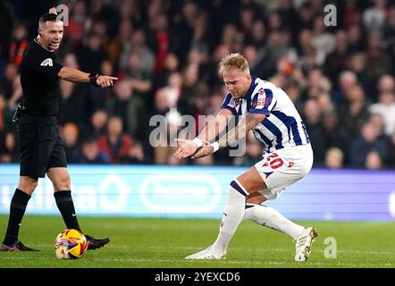 Uros Racic de West Bromwich Albion (à droite) réagit alors que l'arbitre Dean Whitestone arrête de jouer lors du Sky Bet Championship match à Kenilworth Road, Luton. Date de la photo : vendredi 1er novembre 2024. Banque D'Images