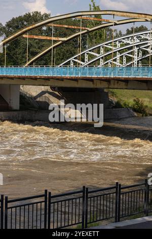 De l'eau qui coule sous un pont en acier après de fortes pluies, capturant le pouvoir de la nature et des infrastructures urbaines dans la prévention des inondations Banque D'Images