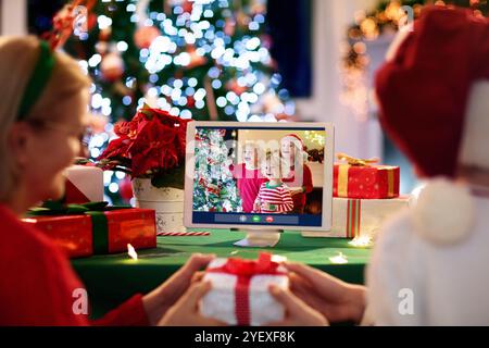 Appel vidéo le jour de Noël. Famille à Santa Hat ayant une conférence en ligne à la veille de Noël. Se connecter à ses proches et à ses amis pendant la période des fêtes. Banque D'Images