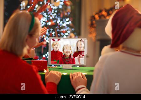 Appel vidéo le jour de Noël. Famille à Santa Hat ayant une conférence en ligne à la veille de Noël. Se connecter à ses proches et à ses amis pendant la période des fêtes. Banque D'Images