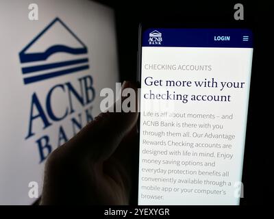 Dans cette illustration photo, une personne tient un smartphone avec la page Web de la société américaine de services financiers ACNB Corporation. Banque D'Images