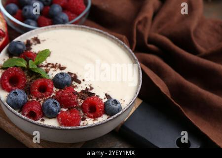 Savoureux porridge de semoule cuit avec des baies, du chocolat et de la menthe sur la table, gros plan Banque D'Images