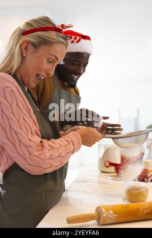 Temps de Noël, couple multiracial cuisiner ensemble à la maison, profiter des préparations de vacances festives Banque D'Images