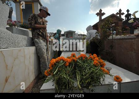 Amealco de Bonfil, Mexique. 01 novembre 2024. Des parents décorent les tombes de leurs proches avec des fleurs de cempasuchil et tiennent une veillée au cimetière municipal d'Amealco de Bonfil. Dans le cadre des traditions mexicaines du jour des morts, les gens visitent les tombes de leurs défunts pour passer du temps avec eux, selon les croyances les âmes des défunts rentrent chez eux pour passer du temps avec leurs proches et se nourrir avec la nourriture qui leur est offerte. Le 1er novembre 2024 à Amealco de Bonfil, Mexique. (Photo de Fernando Camacho/ crédit : Eyepix Group/Alamy Live News Banque D'Images