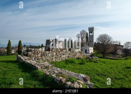 Le château de Fagagna dans le Frioul (Italie) au sommet d'une colline, avec sa tour de l'horloge, l'église et le mur de pierre de la forteresse dans un matin ensoleillé de l'été.. Banque D'Images