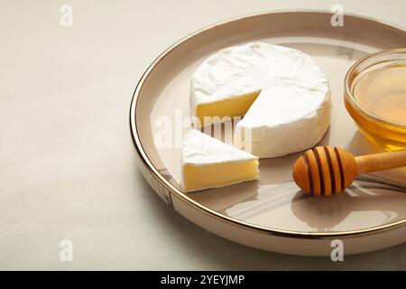 Miel frais avec du fromage camembert sur fond clair. Vue de dessus Banque D'Images