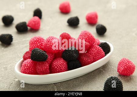 Bonbons à la framboise et à la mûre sur fond gris. Banque D'Images